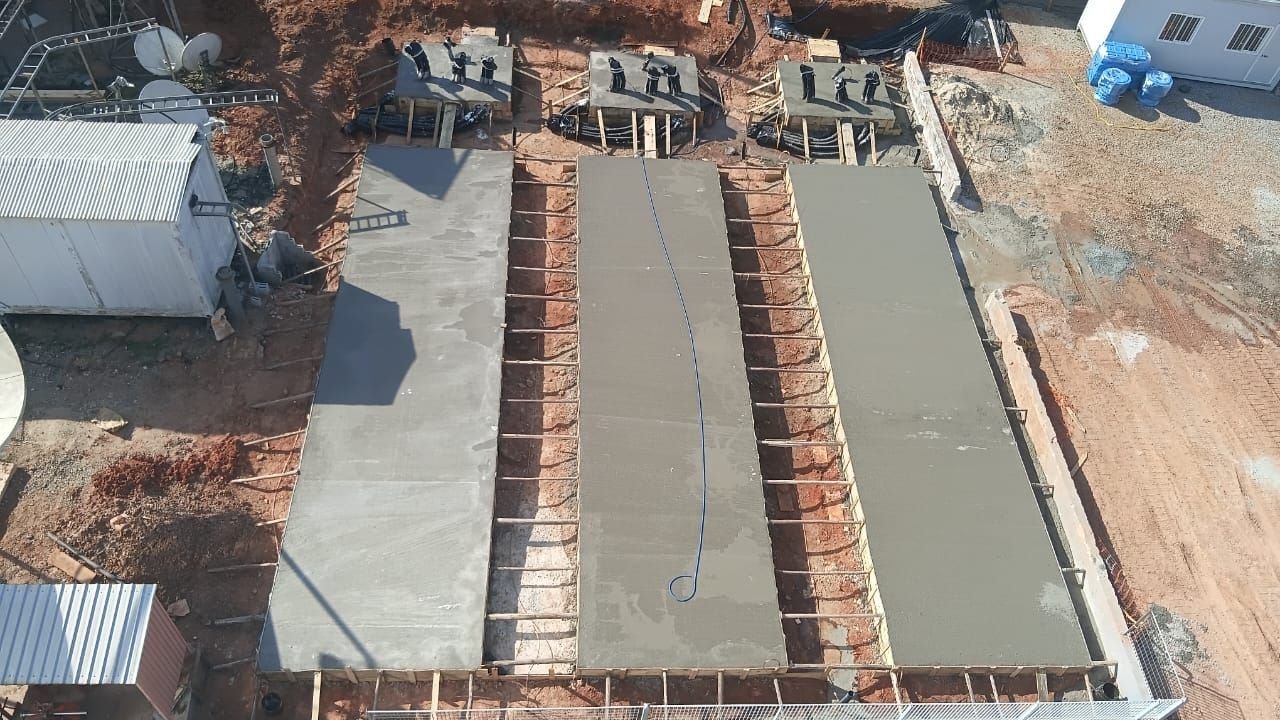 Vista aérea de fundação concretada em obra, com fôrmas de madeira